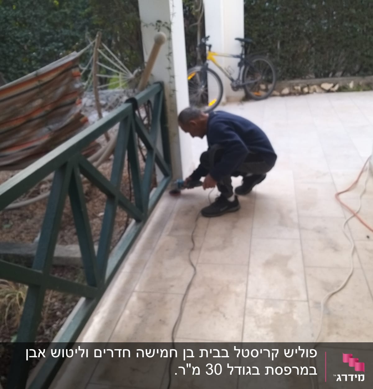 אדם מנקה רצפה עם מכשיר חשמלי במרפסת